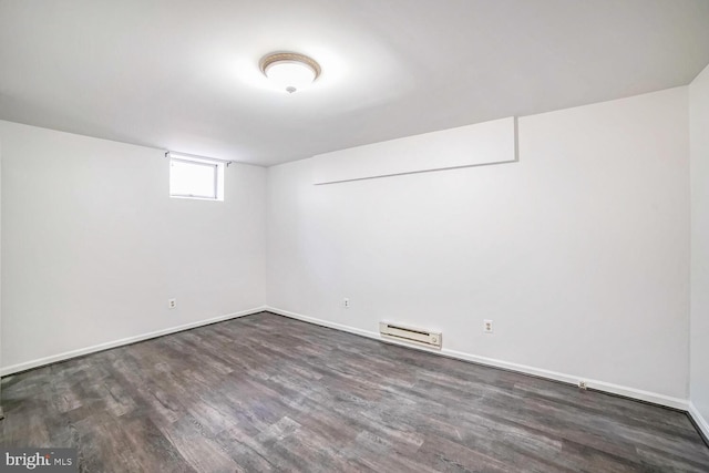 basement featuring dark wood-type flooring and a baseboard radiator