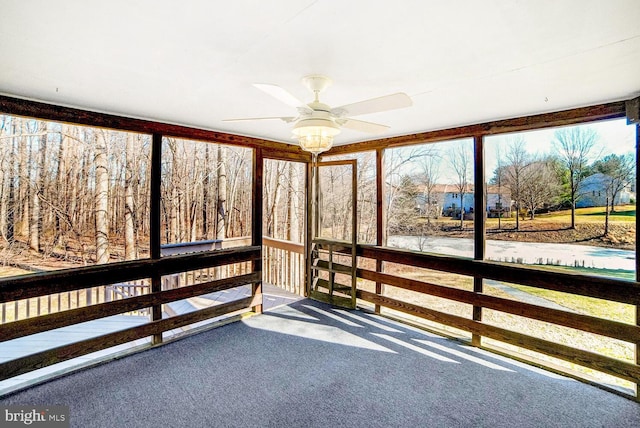 unfurnished sunroom with ceiling fan