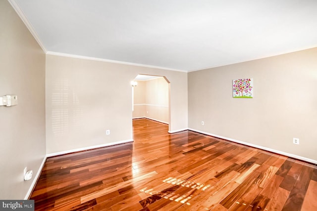 empty room featuring ornamental molding and hardwood / wood-style floors