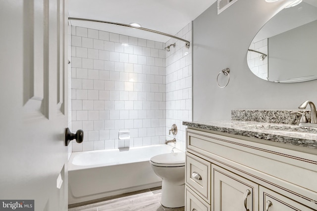 full bathroom with shower / bath combination, visible vents, toilet, wood finished floors, and vanity