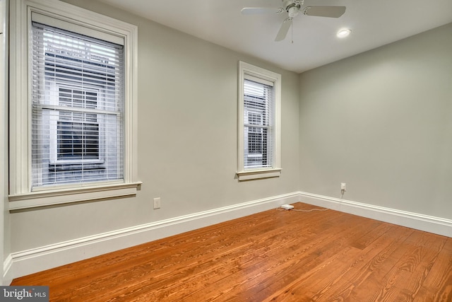 empty room featuring wood finished floors, a ceiling fan, and baseboards