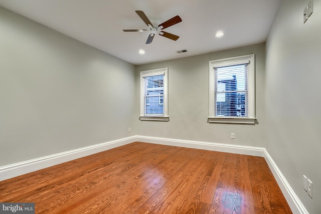 spare room with ceiling fan, recessed lighting, wood finished floors, visible vents, and baseboards