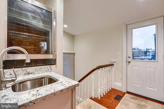 kitchen featuring sink, light hardwood / wood-style floors, and light stone countertops