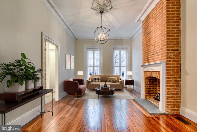 sitting room featuring hardwood / wood-style flooring, crown molding, and a chandelier