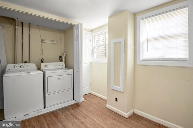 laundry area featuring washing machine and dryer and light hardwood / wood-style floors