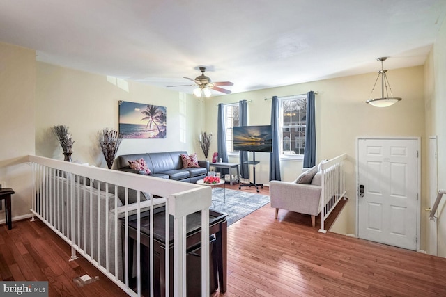 living room with dark wood-type flooring and ceiling fan