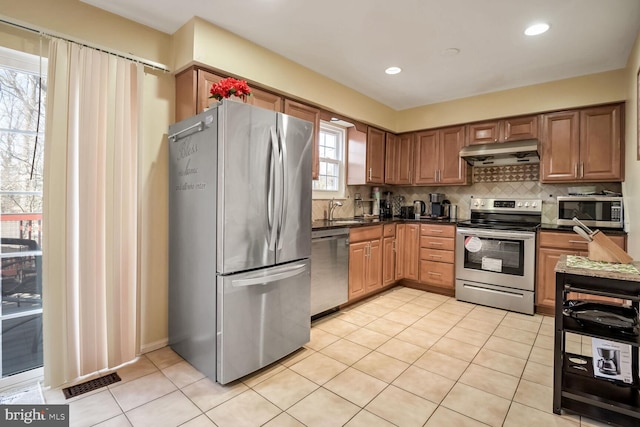 kitchen featuring tasteful backsplash, stainless steel appliances, light tile patterned flooring, and sink