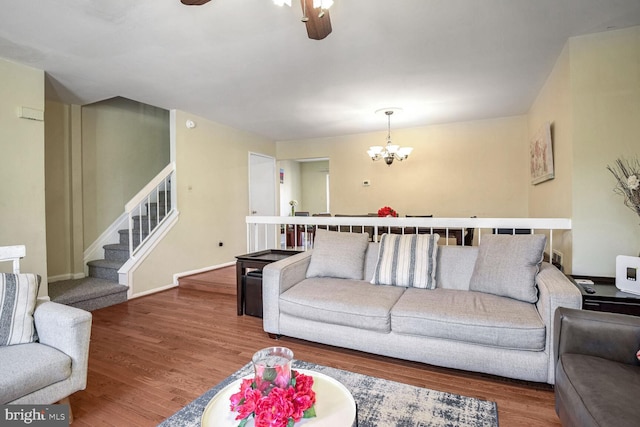 living room featuring hardwood / wood-style flooring and ceiling fan with notable chandelier