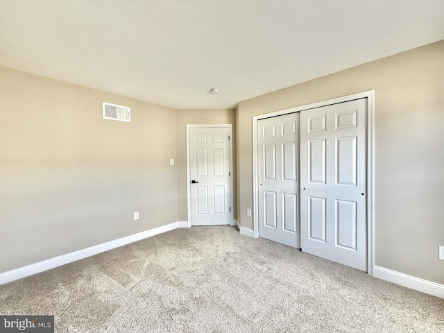 unfurnished bedroom with carpet floors and a closet