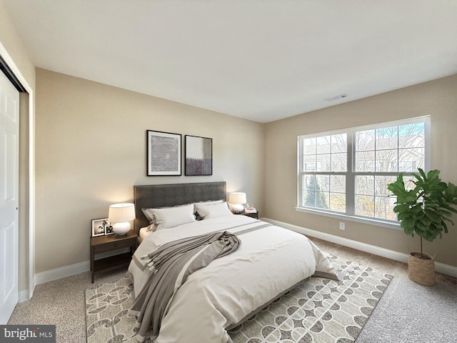 bedroom with light carpet and a closet