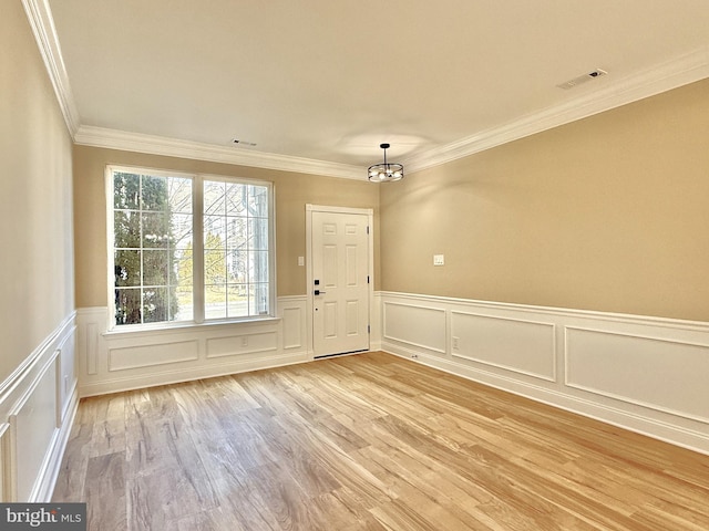 doorway to outside with ornamental molding and light wood-type flooring