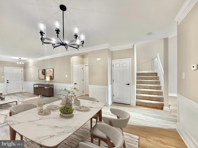 dining space featuring crown molding, a chandelier, and light wood-type flooring