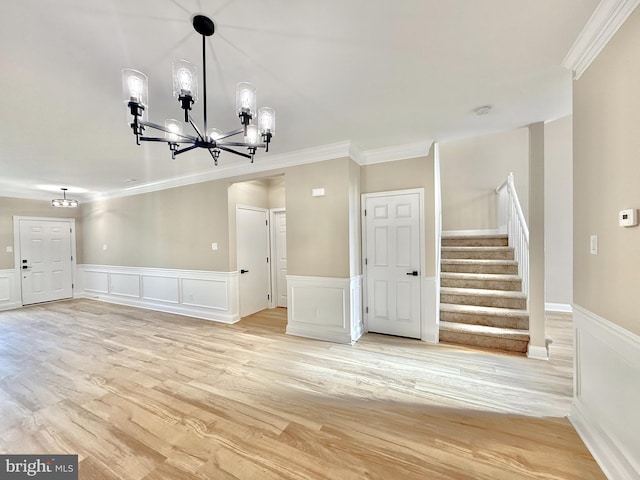 interior space featuring an inviting chandelier, ornamental molding, and light hardwood / wood-style floors