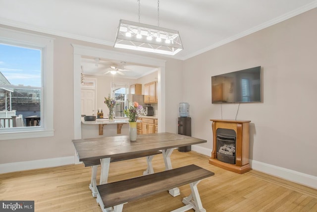 dining area with ceiling fan, ornamental molding, and light hardwood / wood-style floors