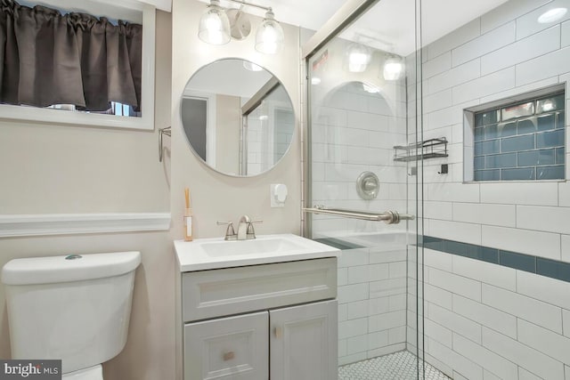 bathroom featuring vanity, toilet, and an enclosed shower