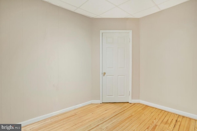 empty room featuring a paneled ceiling and hardwood / wood-style floors