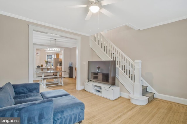 living room featuring hardwood / wood-style flooring, crown molding, and ceiling fan