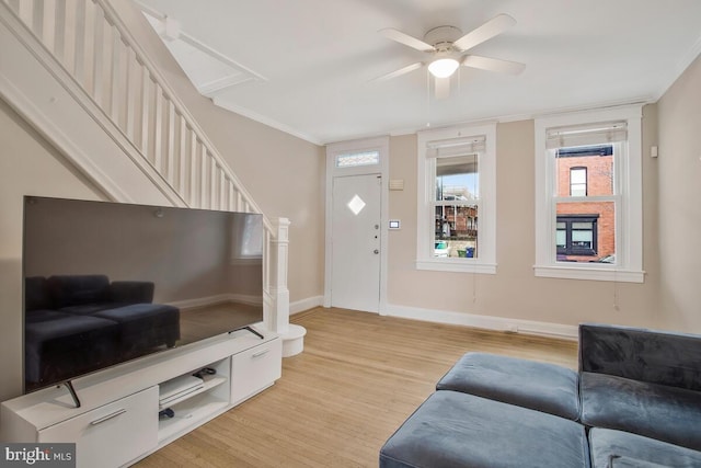 living room featuring crown molding, light hardwood / wood-style flooring, and ceiling fan