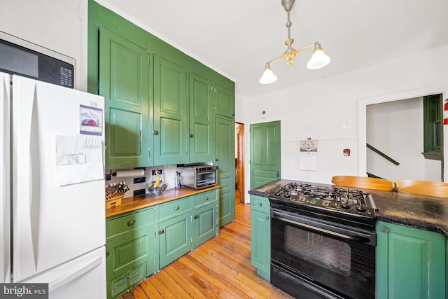 kitchen with green cabinets, black range with gas cooktop, white refrigerator, light hardwood / wood-style floors, and decorative light fixtures