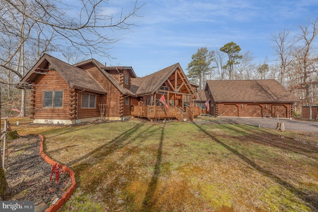 view of front of property with a wooden deck, a front lawn, and a garage