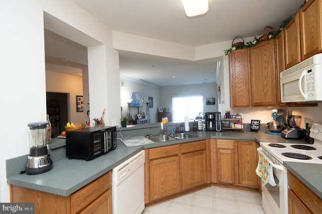 kitchen with sink, white appliances, and kitchen peninsula