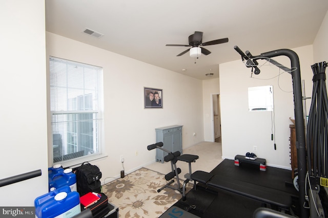 exercise room featuring light colored carpet and ceiling fan