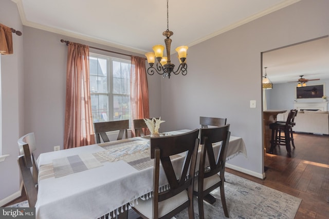 dining room with crown molding, dark hardwood / wood-style flooring, and ceiling fan with notable chandelier