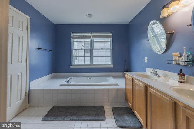 bathroom featuring tiled tub, vanity, and tile patterned floors