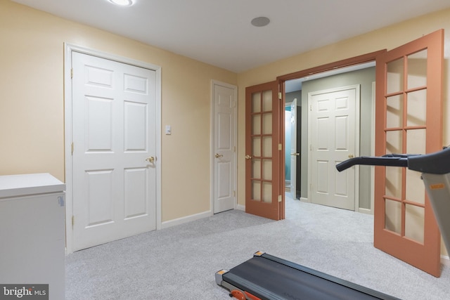 workout area featuring light colored carpet and french doors