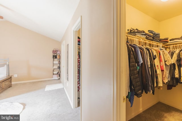 walk in closet featuring lofted ceiling and carpet flooring