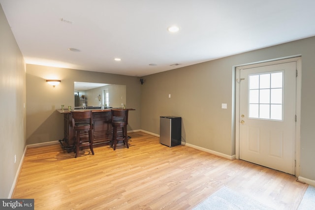 bar with light hardwood / wood-style flooring