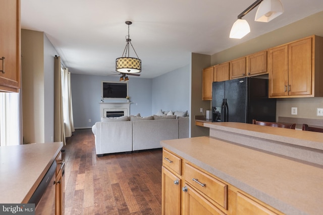 kitchen featuring black fridge, dark hardwood / wood-style floors, decorative light fixtures, and light brown cabinetry