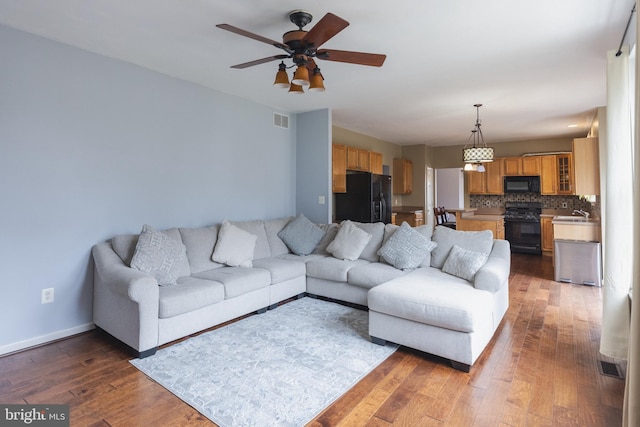 living room with ceiling fan and dark hardwood / wood-style flooring