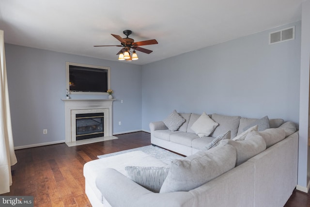 living room with dark hardwood / wood-style flooring, a fireplace, and ceiling fan