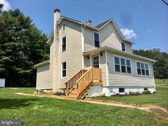 rear view of property with a lawn