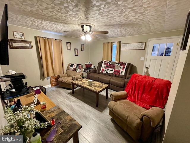 living room featuring hardwood / wood-style floors and ceiling fan