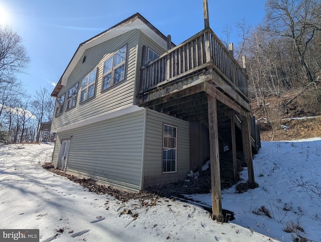 view of snow covered exterior with a deck