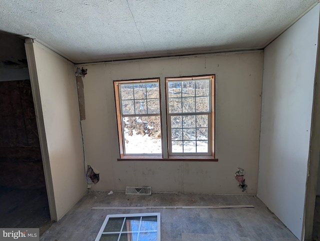 unfurnished room featuring a textured ceiling