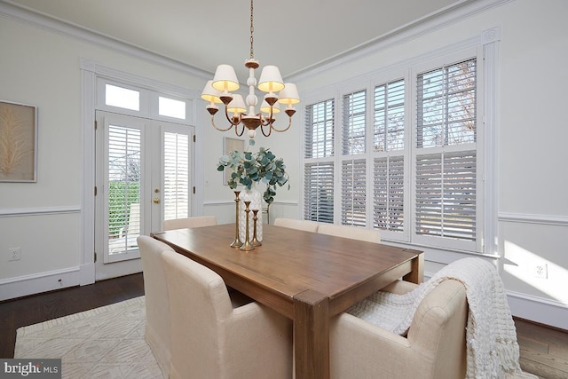 dining room with an inviting chandelier, ornamental molding, french doors, and hardwood / wood-style flooring