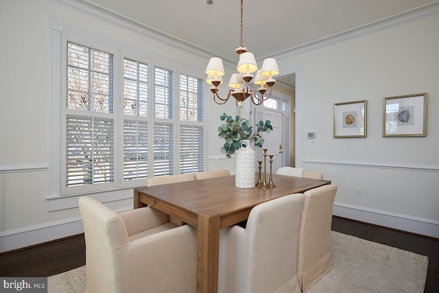 dining space featuring a notable chandelier, crown molding, plenty of natural light, and wood-type flooring