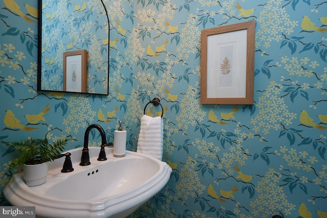 bathroom featuring wallpapered walls and a sink