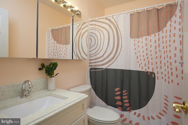 bathroom with toilet, curtained shower, and vanity