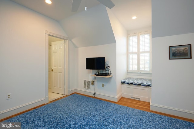 additional living space with baseboards, visible vents, vaulted ceiling, and wood finished floors