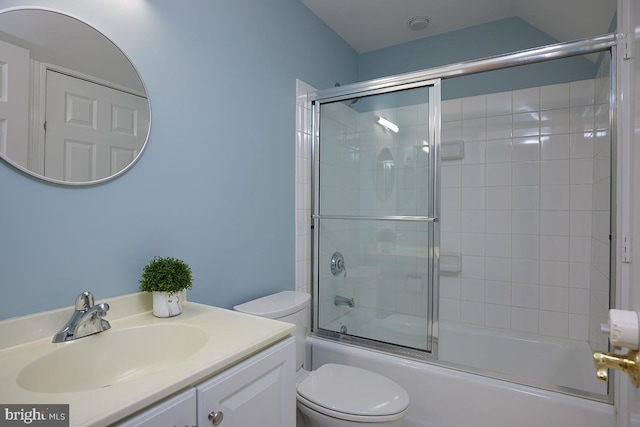 full bathroom featuring vanity, combined bath / shower with glass door, and toilet