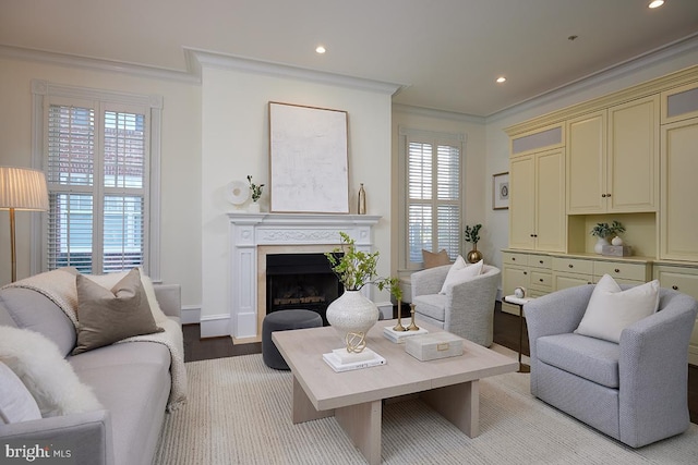 living area featuring a fireplace, recessed lighting, ornamental molding, light wood-style floors, and baseboards