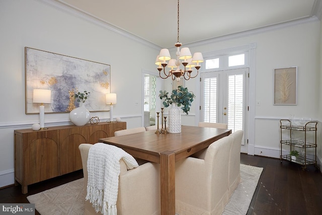 dining area with hardwood / wood-style flooring, crown molding, and an inviting chandelier