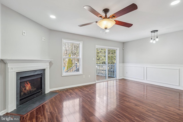 unfurnished living room featuring ceiling fan and dark hardwood / wood-style floors