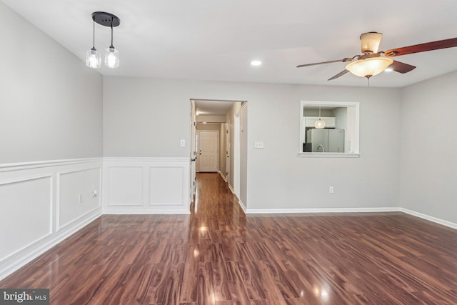 unfurnished room with dark wood-type flooring and ceiling fan