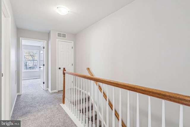 corridor featuring light colored carpet