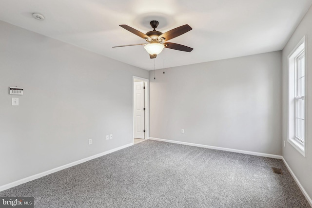 carpeted spare room with ceiling fan